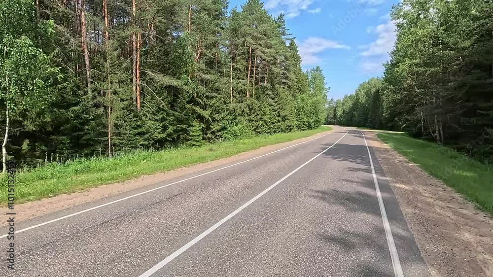 View back to the road on a summer day from a red car. Highways and roadsides move away from the car. View back to the road on a summer day from a red car. Highways and roadsides move away from the car.