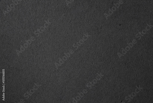 Close-up of dark textured black paper surface, ideal for backgrounds, textures, and minimalist design projects.