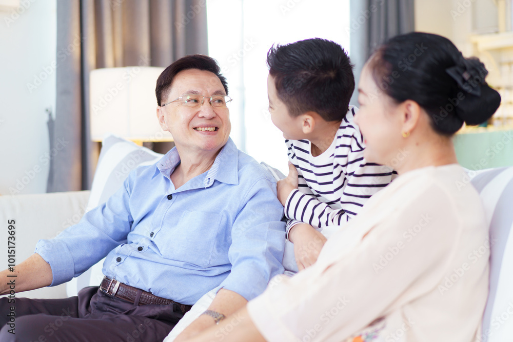 Asian family with father, mother, and son staying in living room together. Asian family with father, mother, and son staying in living room together.