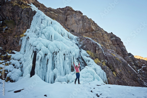 hiker near a frozen Waterfall near Jebel Toubkal peak, Atlas mountains, Morocco photo