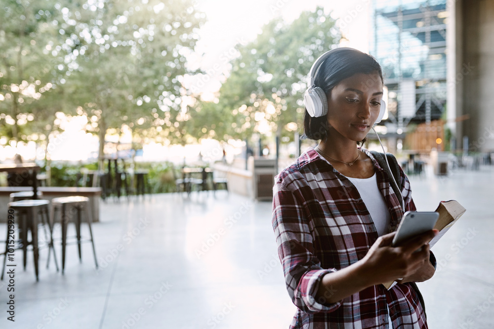 © peopleimages.com - Headphones, girl and student walking with phone for listening to radio, educational podcast and book. Reading, indian person and smartphone on campus with sound app, audio playlist and study music