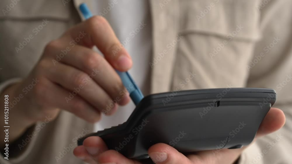 Young businessman using a calculator and laptop calculates expenses, income, money, counting bills, office documents, checking expenses, writing a business budget, accountant, financial work, calculat Young businessman using a calculator and laptop calculates expenses, income, money, counting bills, office documents, checking expenses, writing a business budget, accountant, financial work, calculat