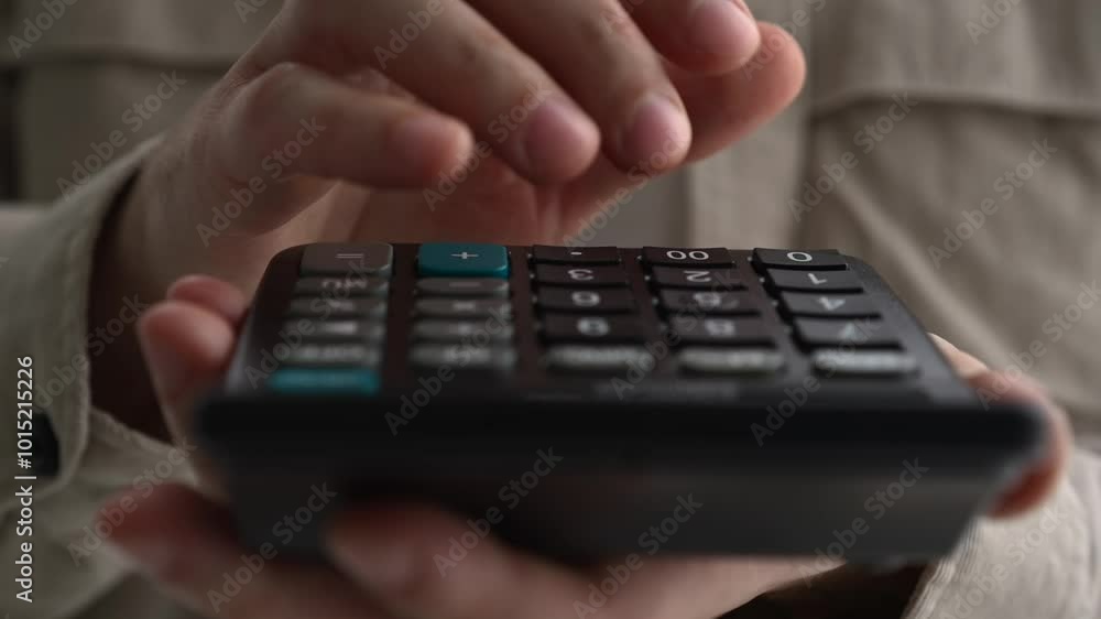 Young businessman using a calculator and laptop calculates expenses, income, money, counting bills, office documents, checking expenses, writing a business budget, accountant, financial work, calculat Young businessman using a calculator and laptop calculates expenses, income, money, counting bills, office documents, checking expenses, writing a business budget, accountant, financial work, calculat