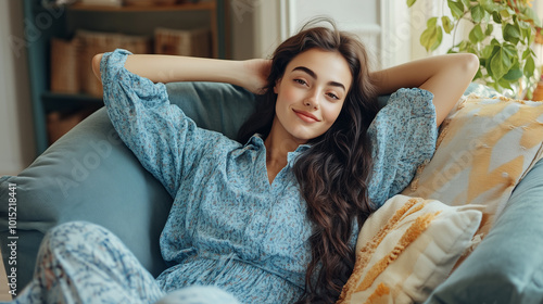 Smiling woman in blue dress relaxing in a comfy armchair.