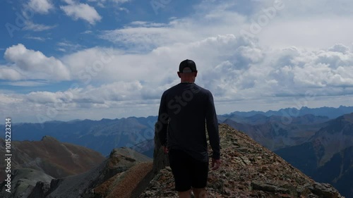 Man Walking On Epic Summit Ridge Panorama In Rocky Mountain Peaks