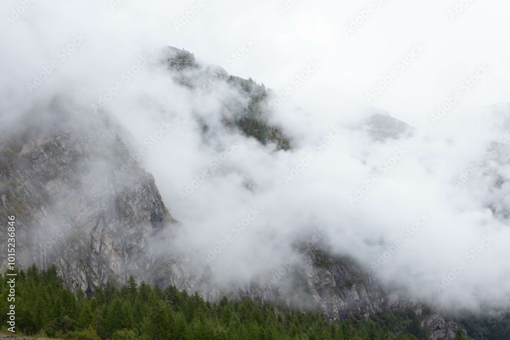 Passing clouds over idyllic landscape in the Alps with snow-capped mountain tops in the background. Passing clouds over idyllic landscape in the Alps with snow-capped mountain tops in the background.