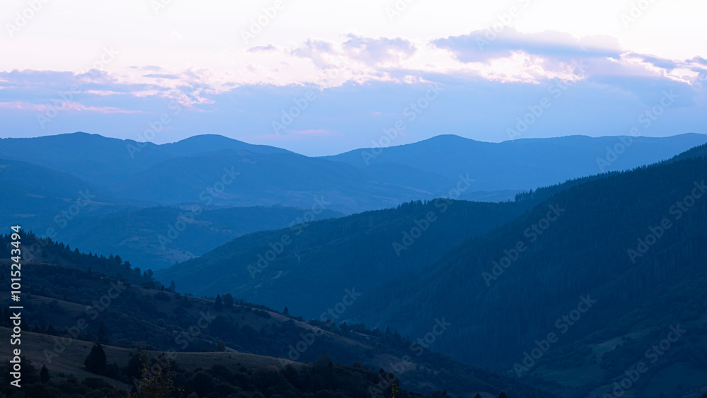 Fototapeta premium Blue sunset with the setting sun behind the mountains