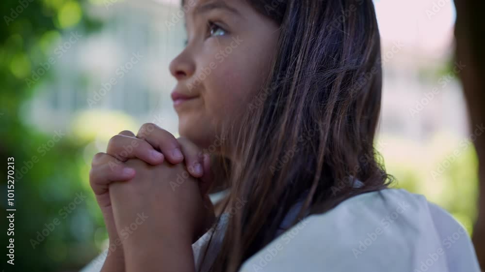 Girl clasping her hands together, eyes closed in deep concentration, evoking a sense of spirituality, hope, and faith. peacefulness in a natural setting Girl clasping her hands together, eyes closed in deep concentration, evoking a sense of spirituality, hope, and faith. peacefulness in a natural setting