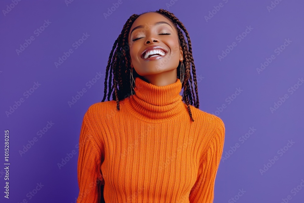 Smiling woman with braided hairstyle wearing a cozy orange turtleneck posing against a vibrant purple background Smiling woman with braided hairstyle wearing a cozy orange turtleneck posing against a vibrant purple background