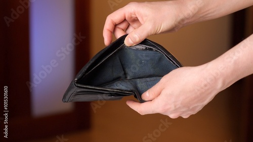 Person holding empty wallet showing financial problem