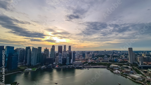 Wallpaper Mural Scenic aerial view of Singapore iconic skyline at dusk. Towering skyscrapers, illuminated by setting sun. Marina Bay waterfront with its bustling activity and vibrant lights. SkyPark Observation Deck Torontodigital.ca
