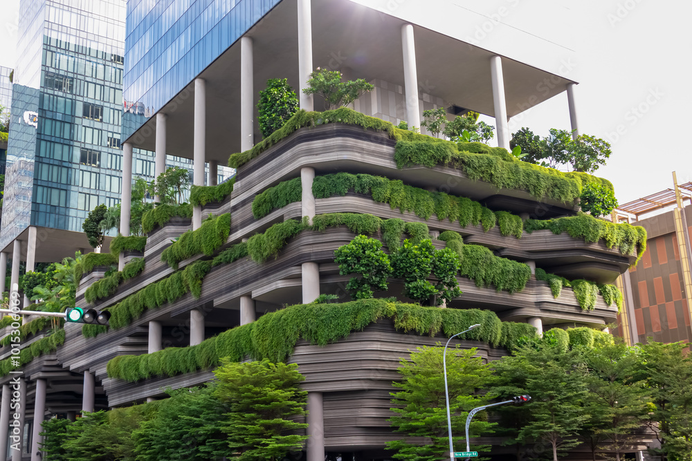Modern, eco-friendly building with extensive green walls and rooftop gardens in Singapore. Facade is covered in lush vegetation, creating a striking contrast with the surrounding urban environment