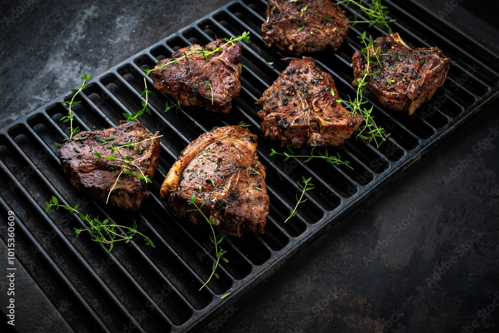 Authentic barbecued T-Bone lamb steak with thyme served as close-up on a rustic grillage Authentic barbecued T-Bone lamb steak with thyme served as close-up on a rustic grillage
