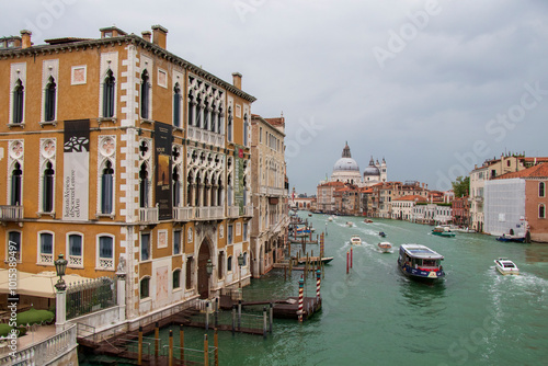 Grand Canal View with Historic Buildings and Basilica in Venice. A stunning view of Venice's Grand Canal with ornate buildings and the iconic Santa Maria della Salute Basilica. photo