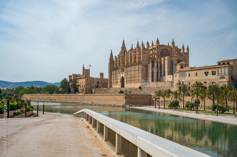 Cathedral of Santa Maria of Palma La Seu in Palma de Mallorca with lake and park, with path and fence in front, majorca Cathedral of Santa Maria of Palma La Seu in Palma de Mallorca with lake and park, with path and fence in front, majorca