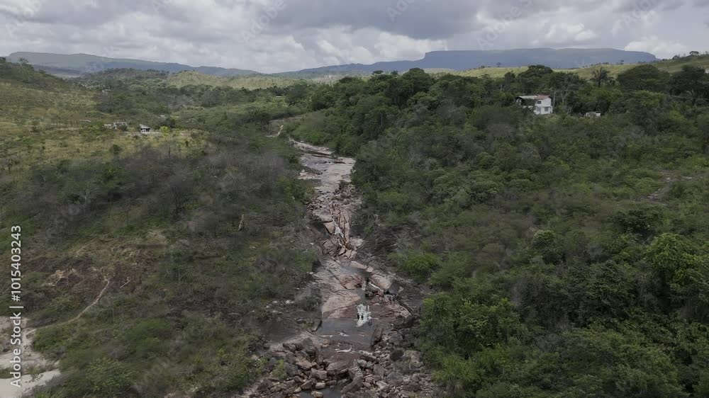 Drone flies up and away from Cachoeira do Barata waterfall to reveal entire valley on cloudy afternoon in Tepequem, Roraima, Brazil Drone flies up and away from Cachoeira do Barata waterfall to reveal entire valley on cloudy afternoon in Tepequem, Roraima, Brazil