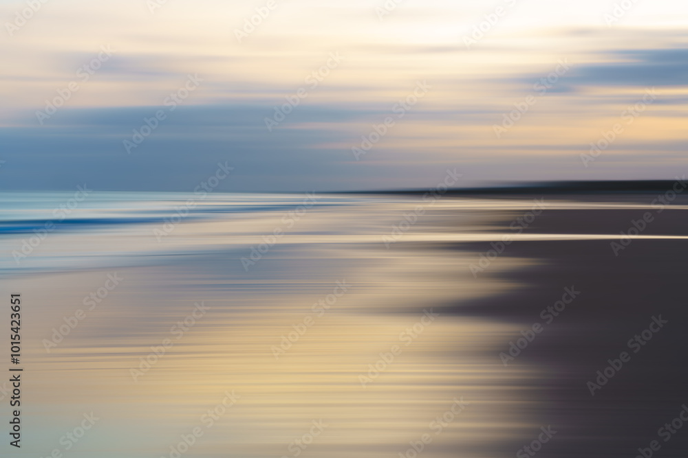 Fototapeta premium Abstract motion blur of ocean waves and sky in soft, muted tones.