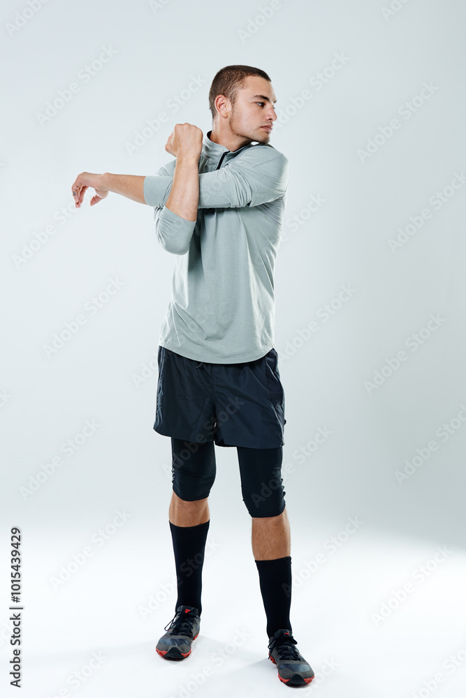 Man, stretching and thinking in studio for fitness, warm up and start of football practice. Athlete, ready and arm exercise on white background for sport, healthy body and wellness with flexibility Man, stretching and thinking in studio for fitness, warm up and start of football practice. Athlete, ready and arm exercise on white background for sport, healthy body and wellness with flexibility