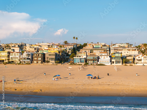 Εκτύπωση καμβά Manhattan Beach in California features a wide sandy shoreline, diverse beachfront houses, palm trees, and a few people relaxing under umbrellas