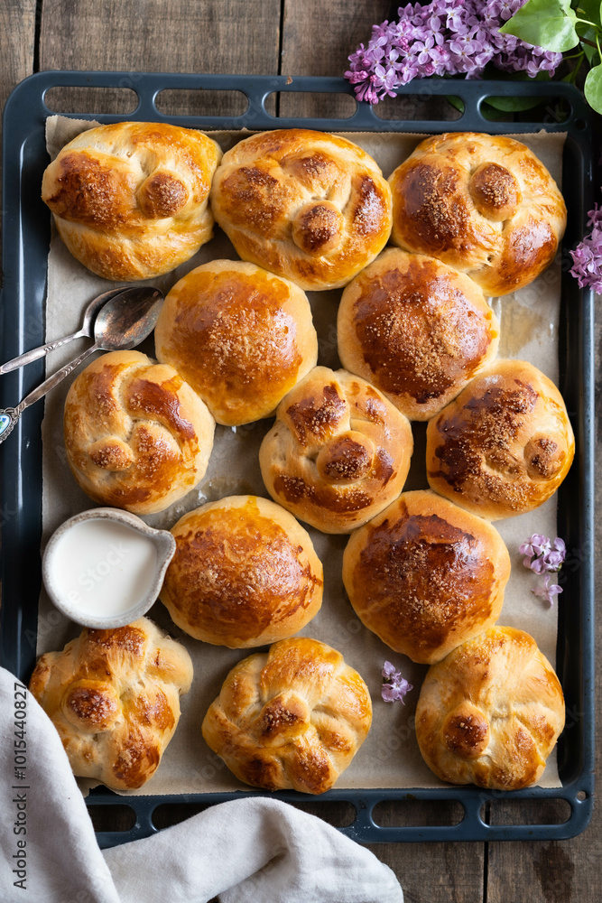 Freshly baked homemade buns arranged on a baking tray, captured from a top-down perspective. Freshly baked homemade buns arranged on a baking tray, captured from a top-down perspective.