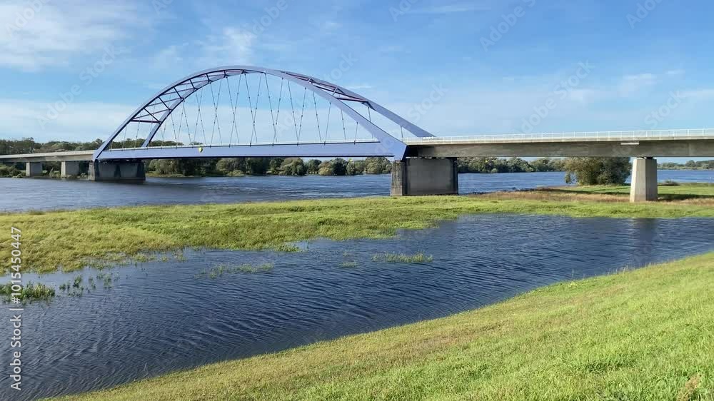 Modern arch bridge over a wide river under a clear sky, Bridge of Unity, Elbe, Brandenburg, Germany, Europe Modern arch bridge over a wide river under a clear sky, Bridge of Unity, Elbe, Brandenburg, Germany, Europe