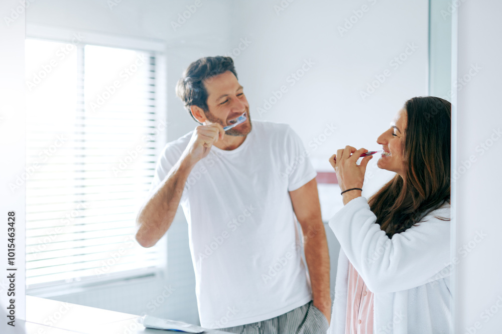 Obraz premium Brushing teeth, happy and toothbrush with couple in bathroom for oral hygiene, breath and cleaning. Self care, wellness and dental with man and woman at home for gum treatment, toothpaste or health