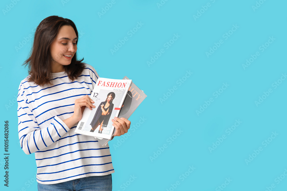 Young woman with magazines on blue background Young woman with magazines on blue background