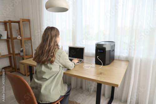 Young woman using laptop wi...