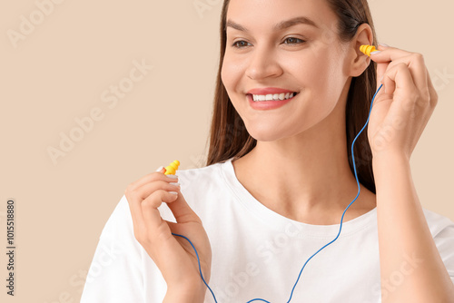 Young woman putting ear plu...