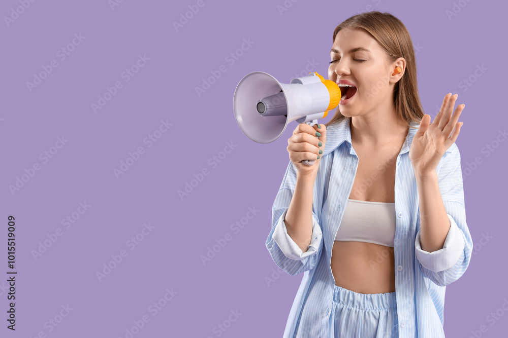 Young woman with ear plugs shouting into megaphone on lilac background Young woman with ear plugs shouting into megaphone on lilac background