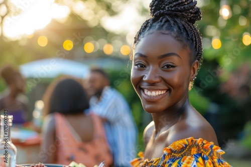 Portrait of a smiling young black woman attending a barbecue on a summer day photo