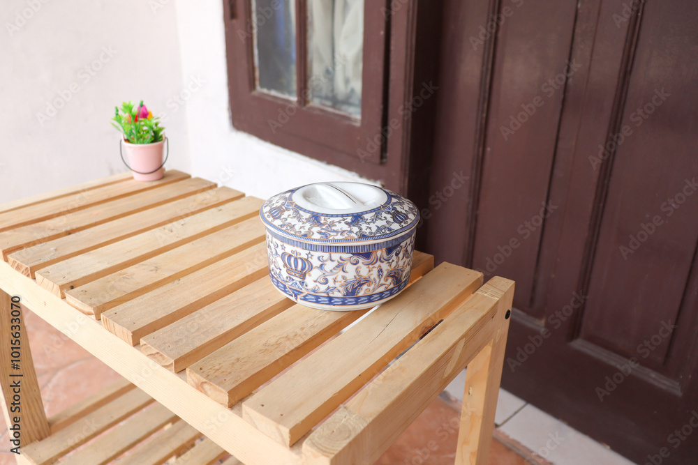 Obraz premium Traditional jar made from porcelain with decorative blue floral pattern on wooden table
