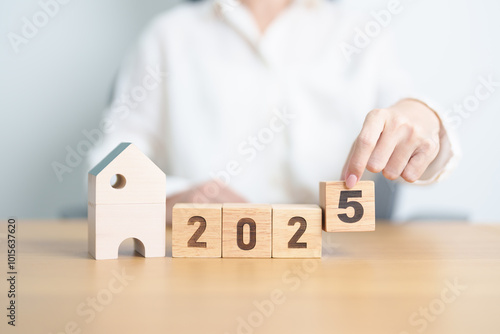 Happy New Year 2025 with house model. real estate, Home loan and mortgage, tax, investment, financial, savings and New Year Resolution concepts