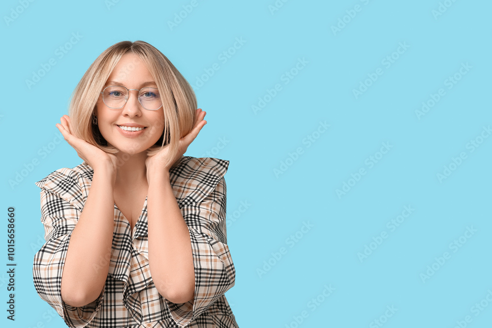 Happy young woman in eyeglasses with bob hairstyle on blue background Happy young woman in eyeglasses with bob hairstyle on blue background