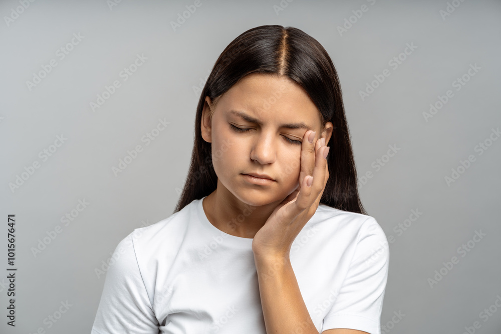 Frustrated, sad teen girl facepalming, rubbing tired eyes against isolated gray wall. Schoolgirl with heavy school workload, sleepless nights, exhaustion from studying, adolescence challenges Frustrated, sad teen girl facepalming, rubbing tired eyes against isolated gray wall. Schoolgirl with heavy school workload, sleepless nights, exhaustion from studying, adolescence challenges