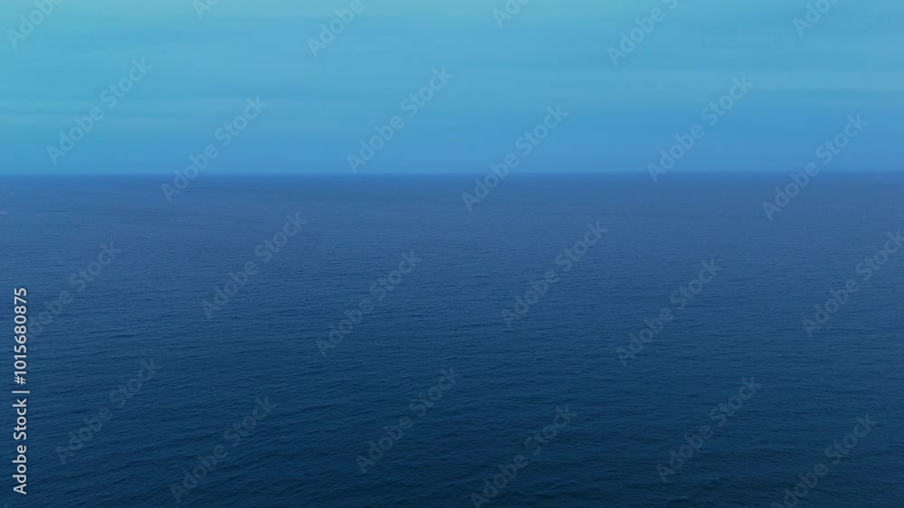 Clear blue ocean water blending into the horizon under a soft pastel sky, peaceful and tranquil Clear blue ocean water blending into the horizon under a soft pastel sky, peaceful and tranquil