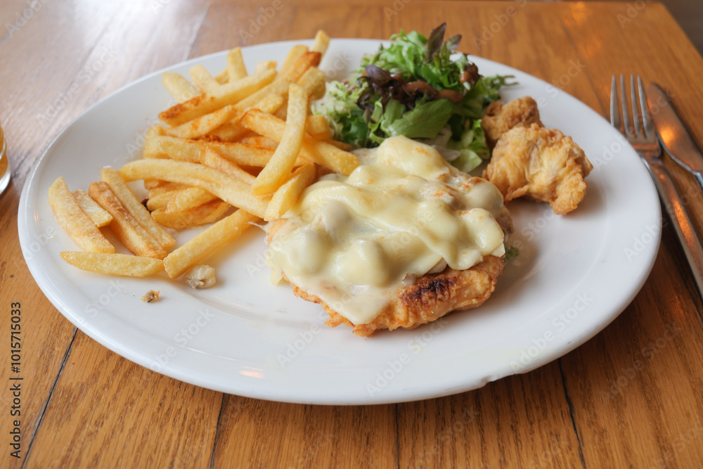 A Delicious and Appetizing Plate of Breaded Chicken Served with Crispy Fries and Fresh Salad A Delicious and Appetizing Plate of Breaded Chicken Served with Crispy Fries and Fresh Salad