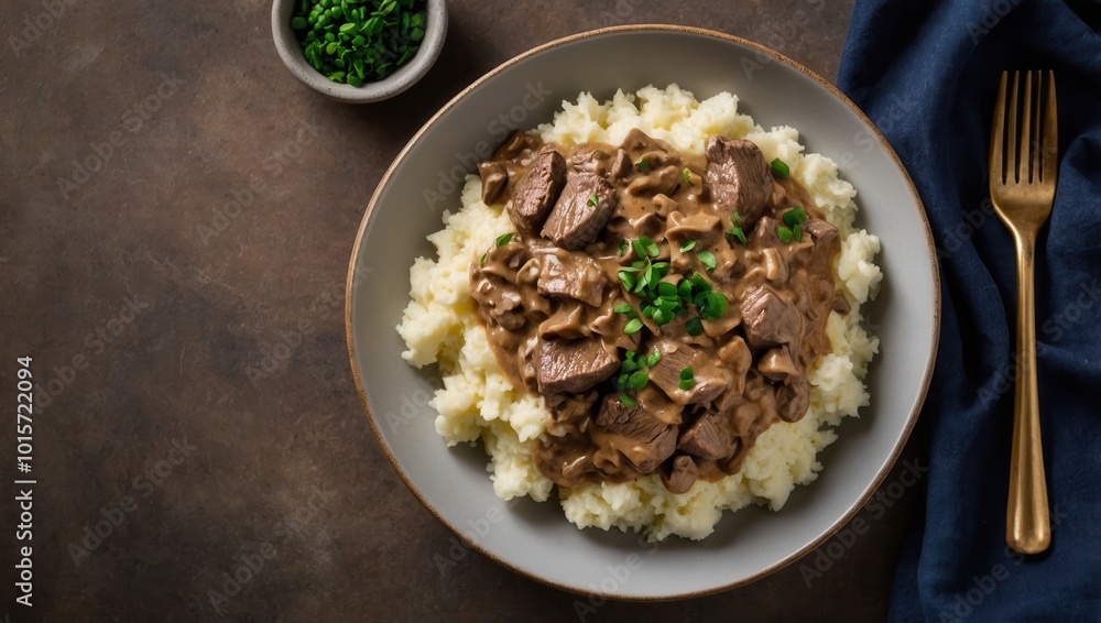 Beef stroganoff with rice and gravy served on a plate, dining table setting Beef stroganoff with rice and gravy served on a plate, dining table setting