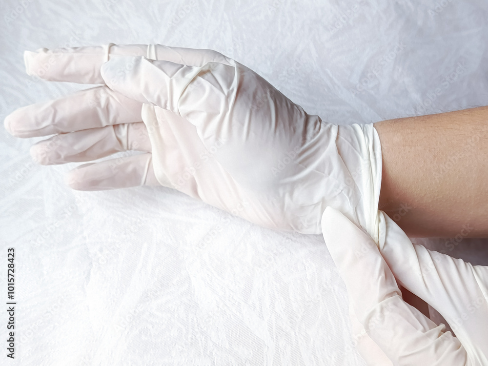 Hand in medical gloves. Doctor puts on medical gloves. Sterility in dentistry, surgery. Medical procedures. Background, space for text. Medical examination. Hand in medical gloves. Doctor puts on medical gloves. Sterility in dentistry, surgery. Medical procedures. Background, space for text. Medical examination.