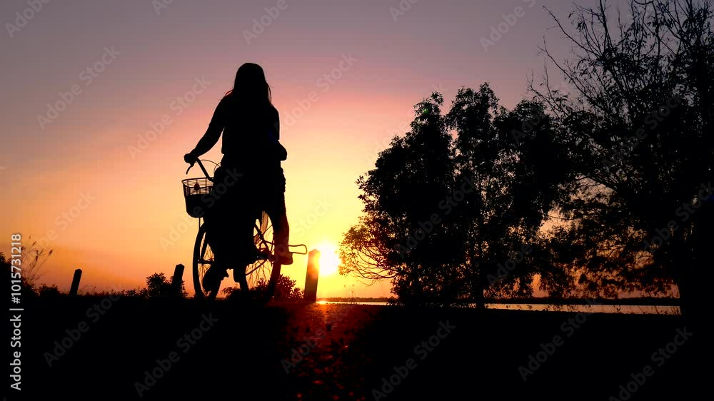 Silhouette of Mother and son ride a bicycle along the bike lane in the park at the sunset. Slow motion shot. 4K Silhouette of Mother and son ride a bicycle along the bike lane in the park at the sunset. Slow motion shot. 4K