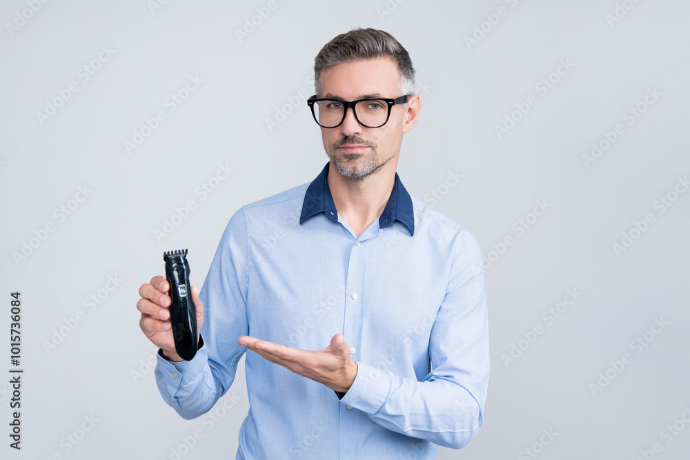 Haircare and shaving. Personal care and daily routine. Barbershop. Hair clipper for man. Man with hair trimmer. Man holding electric shaver. Mature man presenting electric razor. Presenting product Haircare and shaving. Personal care and daily routine. Barbershop. Hair clipper for man. Man with hair trimmer. Man holding electric shaver. Mature man presenting electric razor. Presenting product