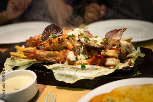 A picture of mixed seafood sizzler with prawns,fish,lobster,squid,vegetables and rice