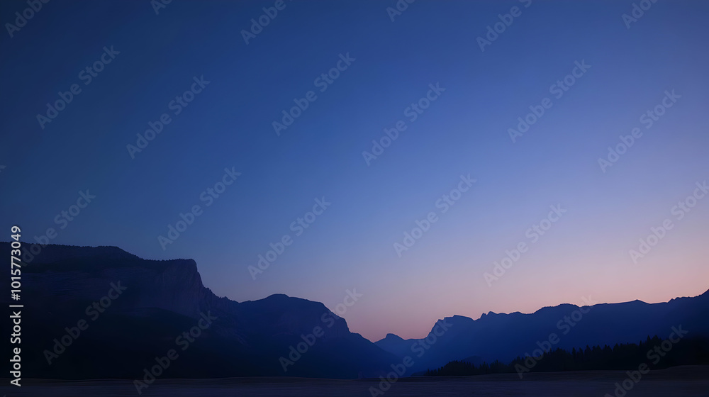 Silhouetted Mountain Range Against a Pale Blue and Pink Twilight Sky Silhouetted Mountain Range Against a Pale Blue and Pink Twilight Sky