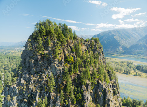 Foto A mountain with a forest on top and a river below