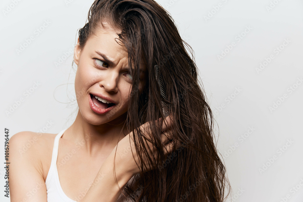 Naklejka premium Hair care, frustration with hair styling, woman with long wet hair, expressive facial expression, indoor white background showing personal grooming concept characters long