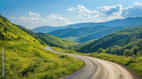 Scenic winding road through lush green hills under a bright blue sky on a sunny day in the countryside