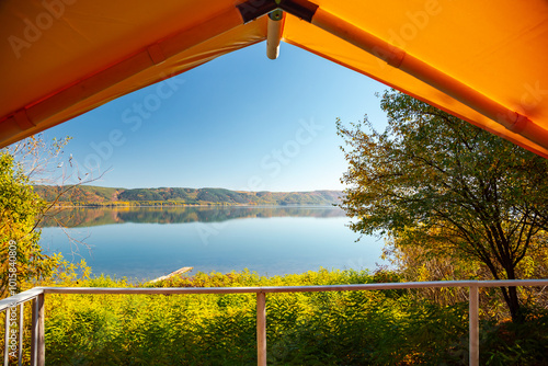 Camping in a cozy bell tent overlooking a quiet lake in the wild.