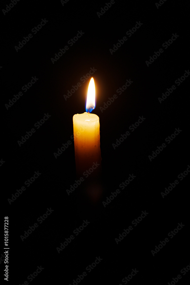 Close-up single candle burning on dark black background, candle fire flame light. Close-up single candle burning on dark black background, candle fire flame light.