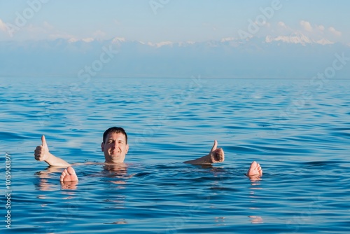 A young man swims in the salty sea