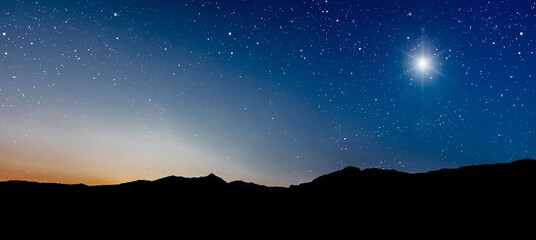 Christmas star shines at night over the mountains of Bethlehem